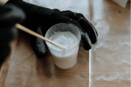 a photo of someone mixing resin in a cup
